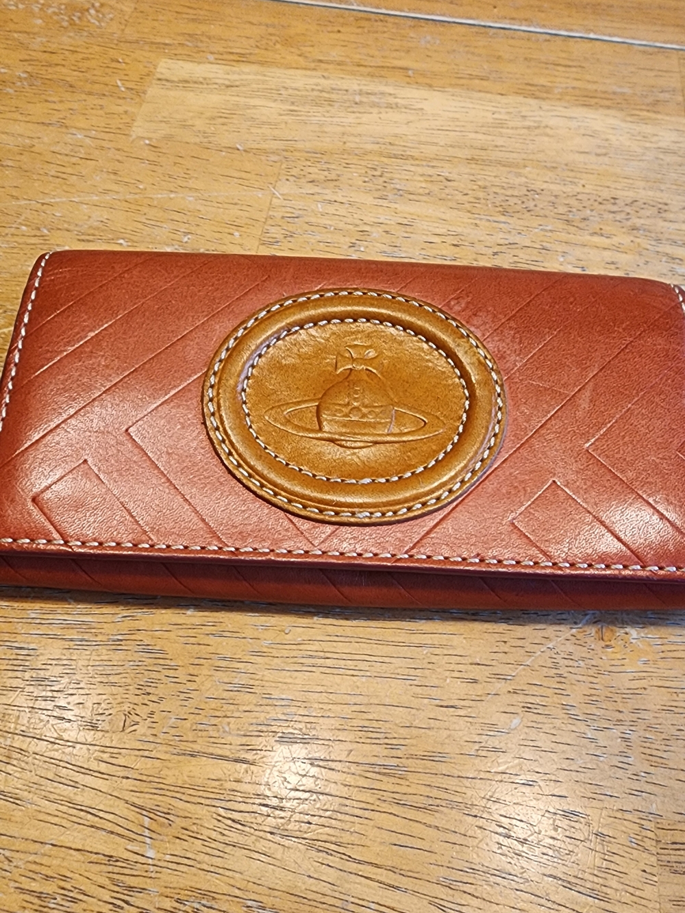 a brown leather Vivienne Westwood long wallet featuring the brand's iconic orb
